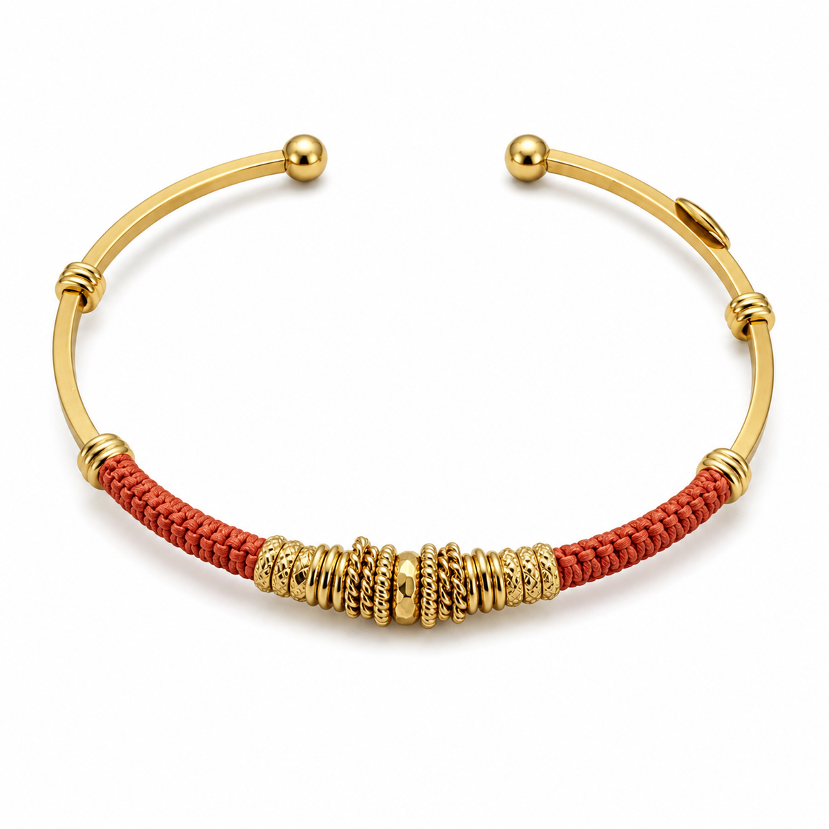 A gold-plated open cuff bracelet featuring a textured red braided cord wrapped around the center and a cluster of decorative gold spacer beads.