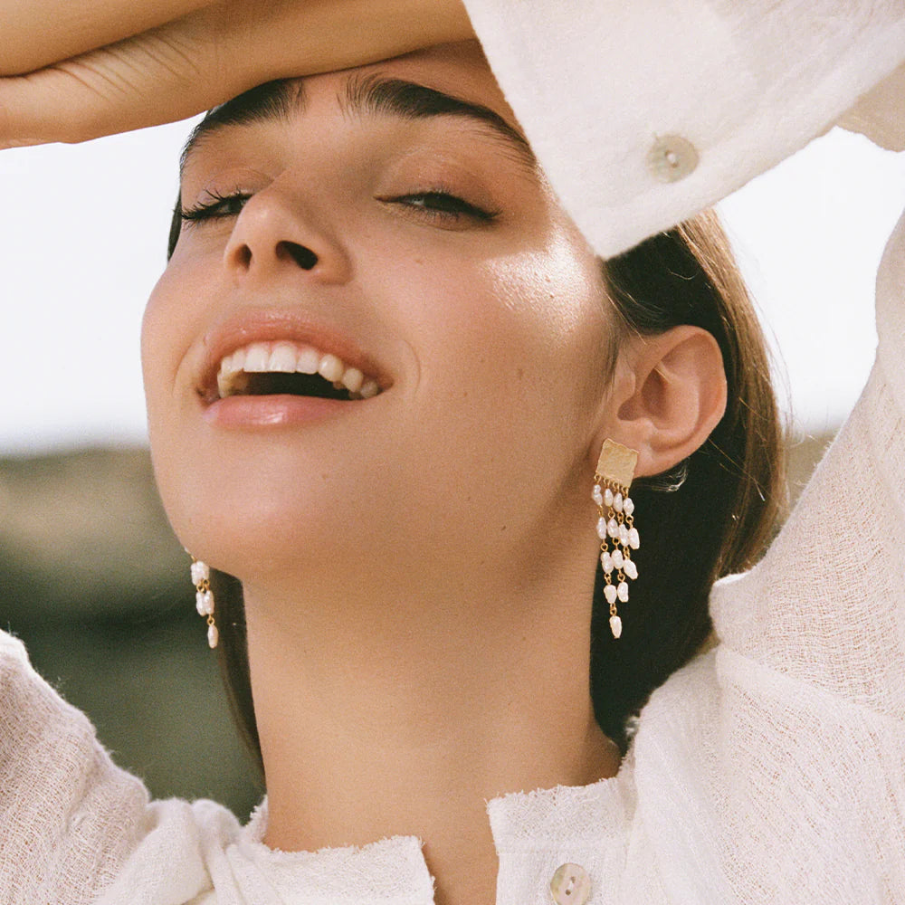Woman wearing pearl earrings with a blurred background
