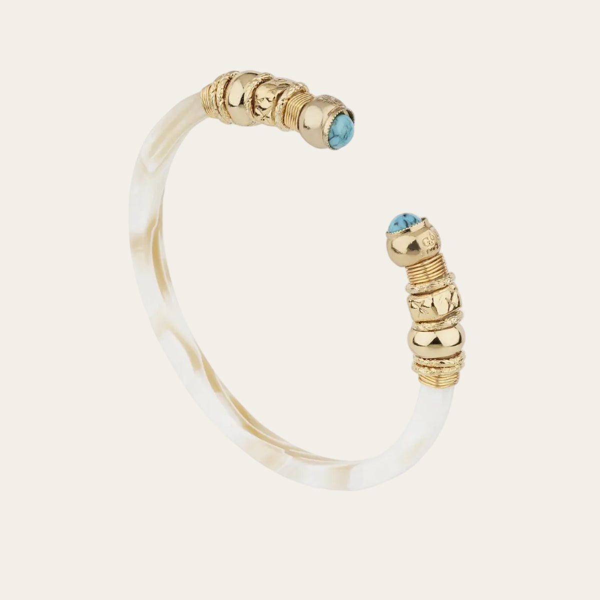 A gold-plated cuff bangle bracelet featuring textured gold bead accents and a small round turquoise gemstone at each end, set against a clean white background.