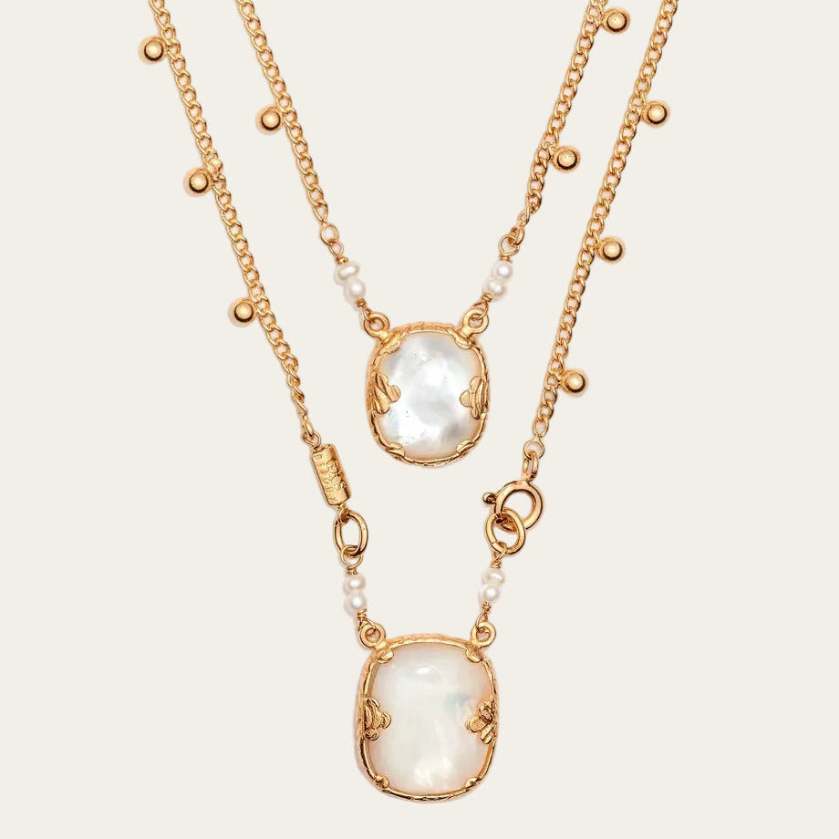 Two gold necklaces with pendant stones on a white background