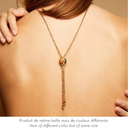 Gold necklace on a person's back with a neutral background
