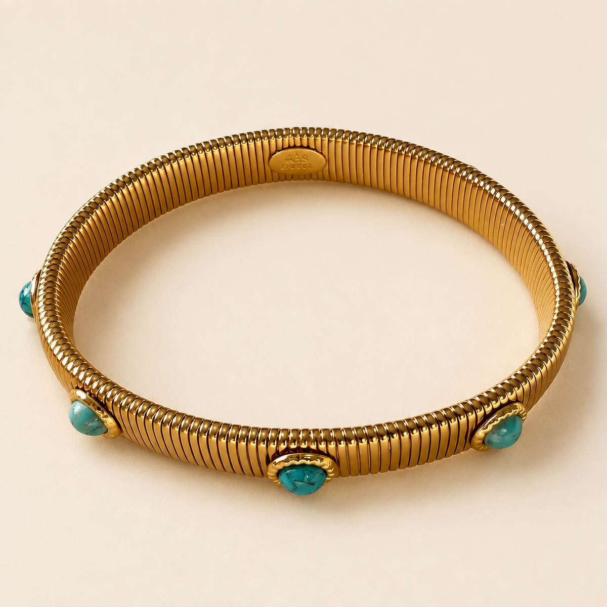 round gold bracelet with turquoise stones around it encase in gold plating